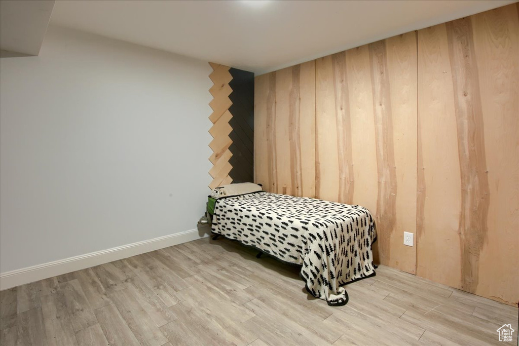 Bedroom featuring wood finished floors and wood walls