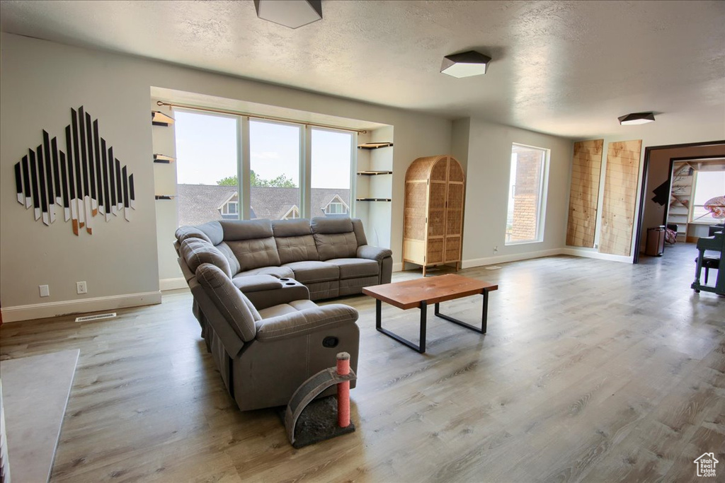 Living area featuring wood finished floors and a textured ceiling