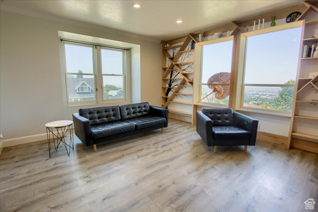 Sitting room featuring wood finished floors, ornamental molding, and recessed lighting