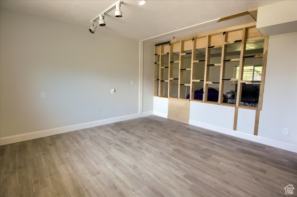 Spare room featuring track lighting and wood finished floors