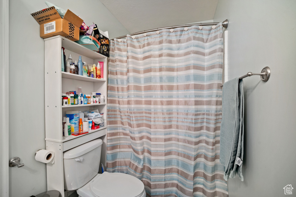Bathroom with toilet and curtained shower
