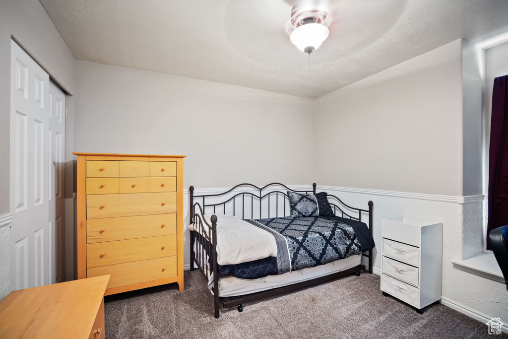 Carpeted bedroom featuring a closet and ceiling fan