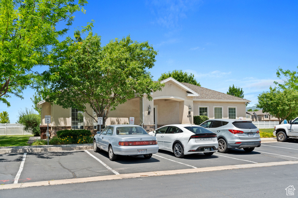 View of front facade featuring uncovered parking and stucco siding