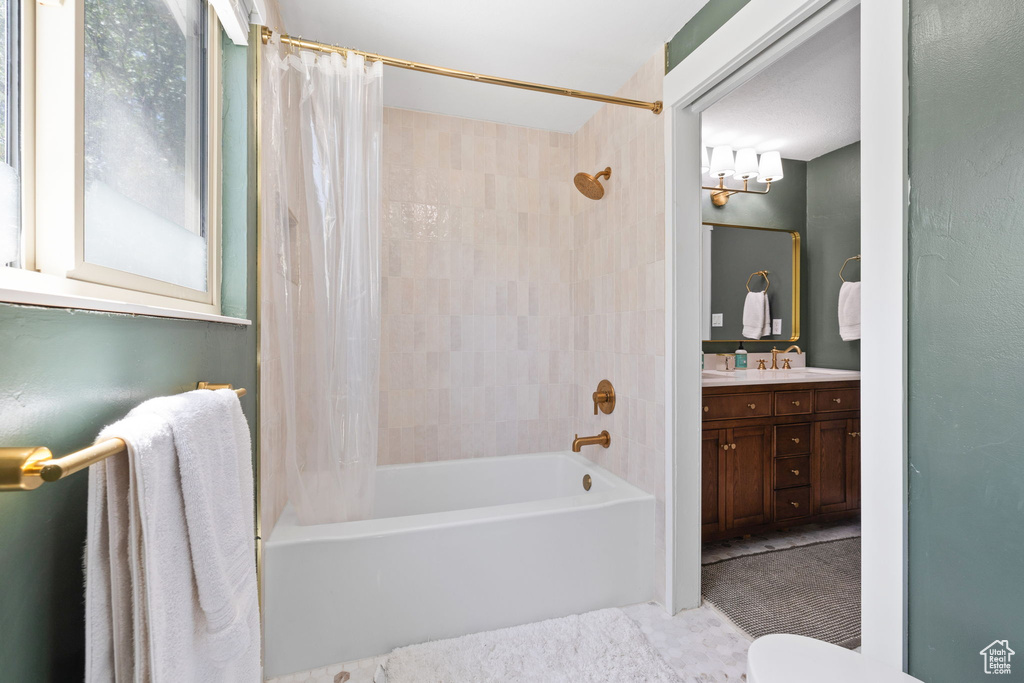 Bathroom with shower / bath combination with curtain and vanity