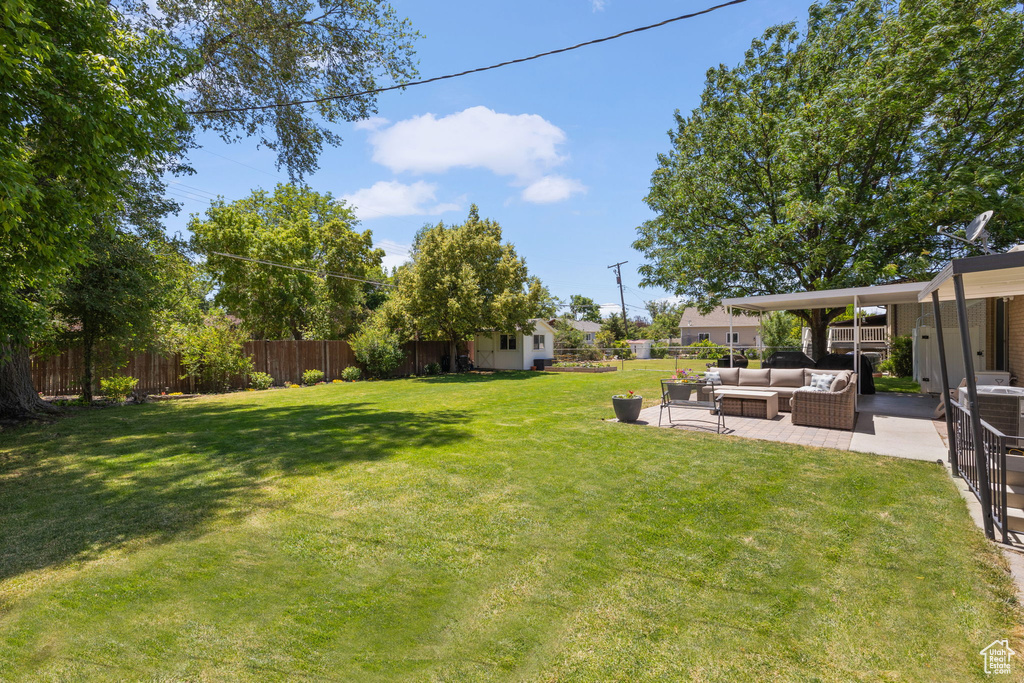 Fenced backyard with outdoor lounge area and a patio