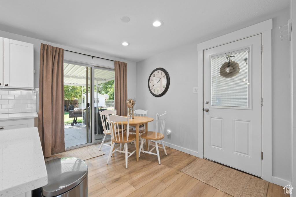 Dining room with light wood-type flooring and recessed lighting