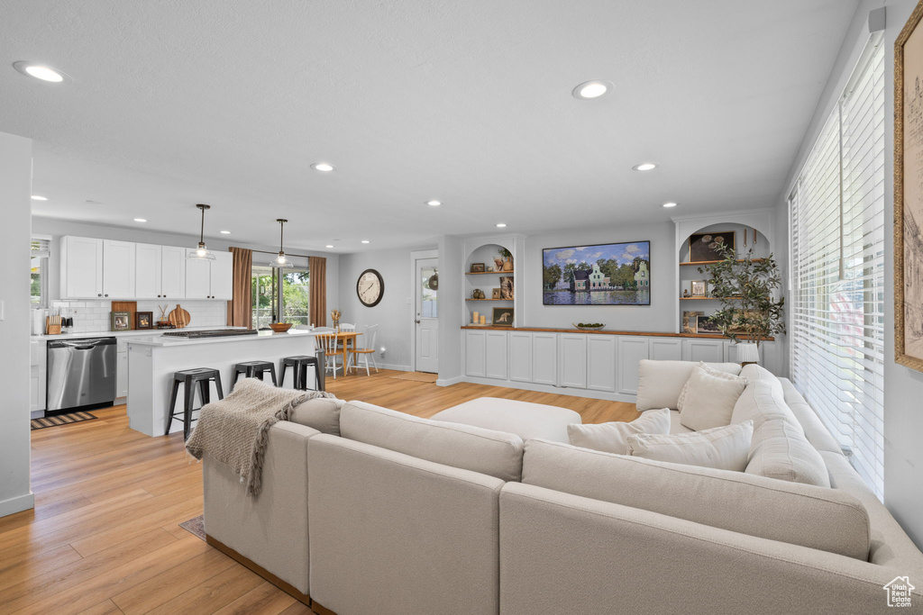Living room featuring recessed lighting, light wood-style floors, and built in features