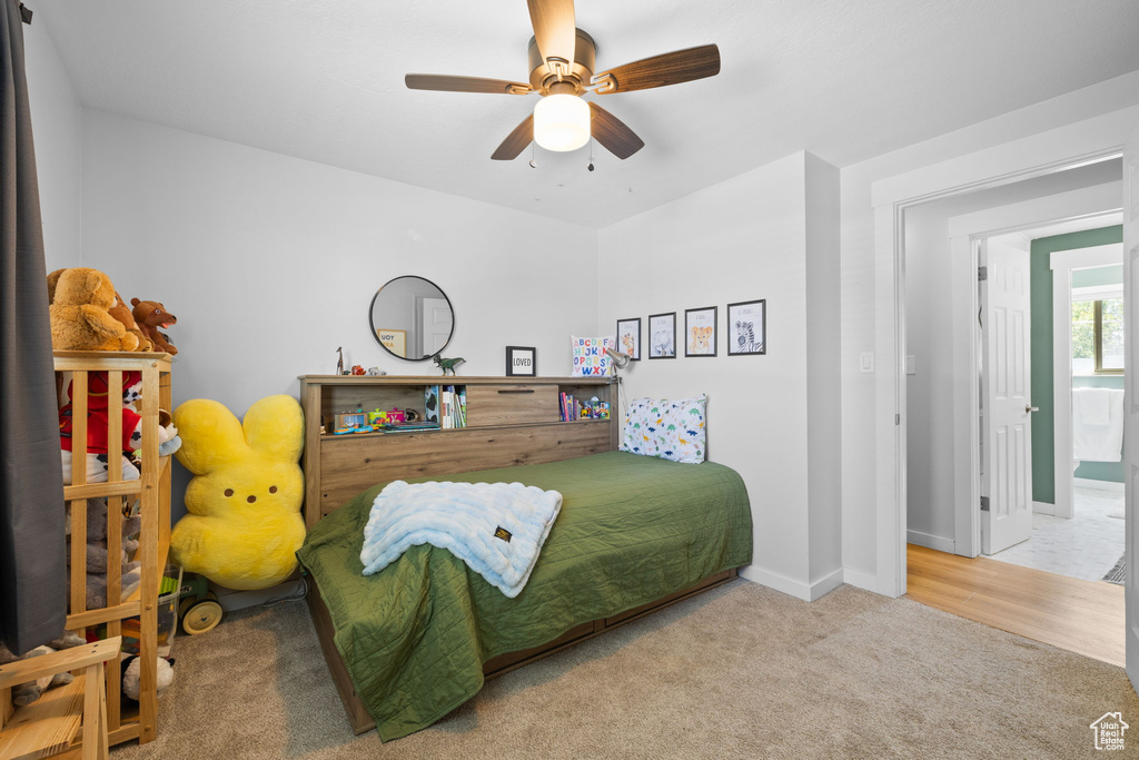 Carpeted bedroom with baseboards and a ceiling fan