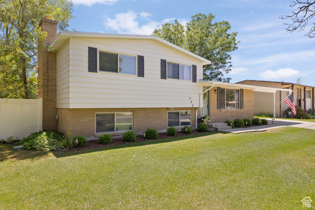 Split level home featuring a chimney and brick siding