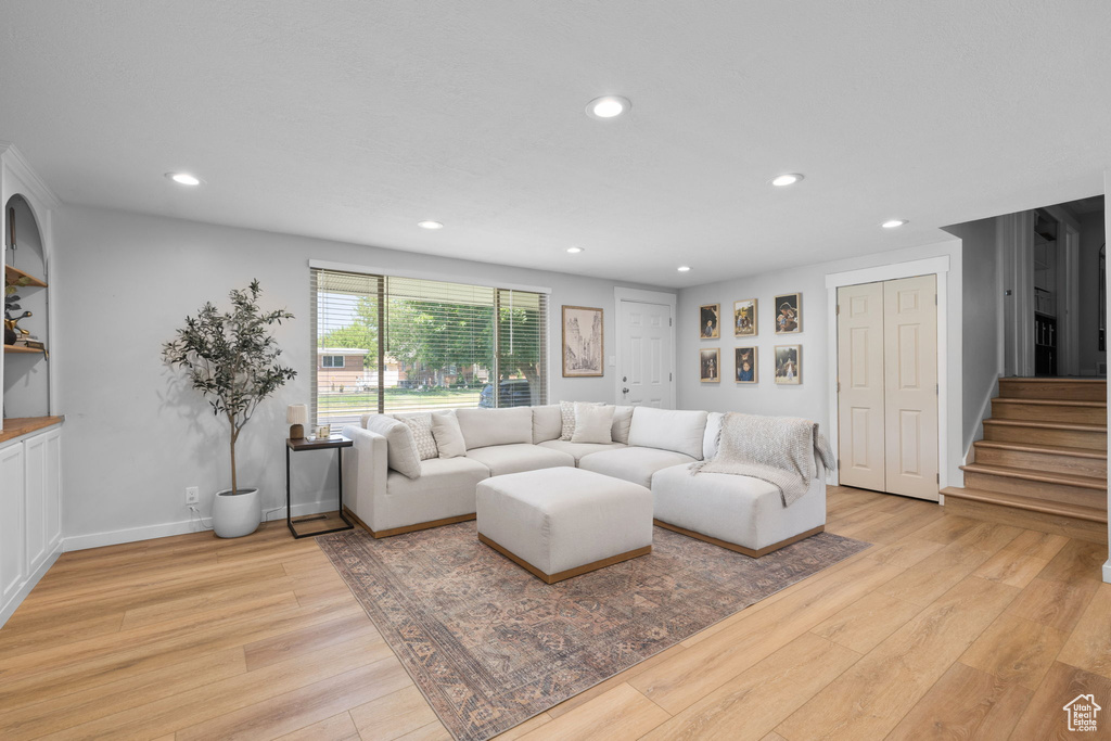 Living area featuring light wood-style floors, recessed lighting, and stairway