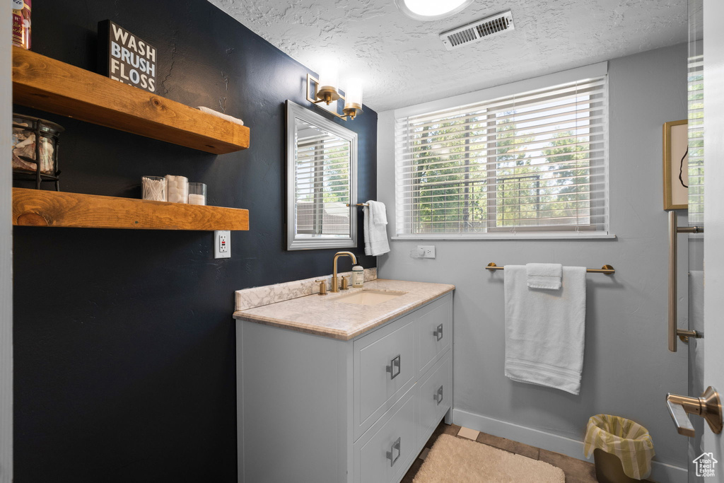 Bathroom with a textured ceiling and vanity