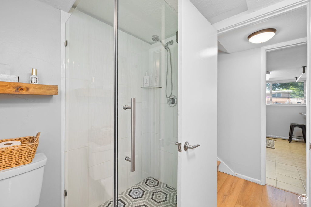 Bathroom featuring a shower stall and wood finished floors