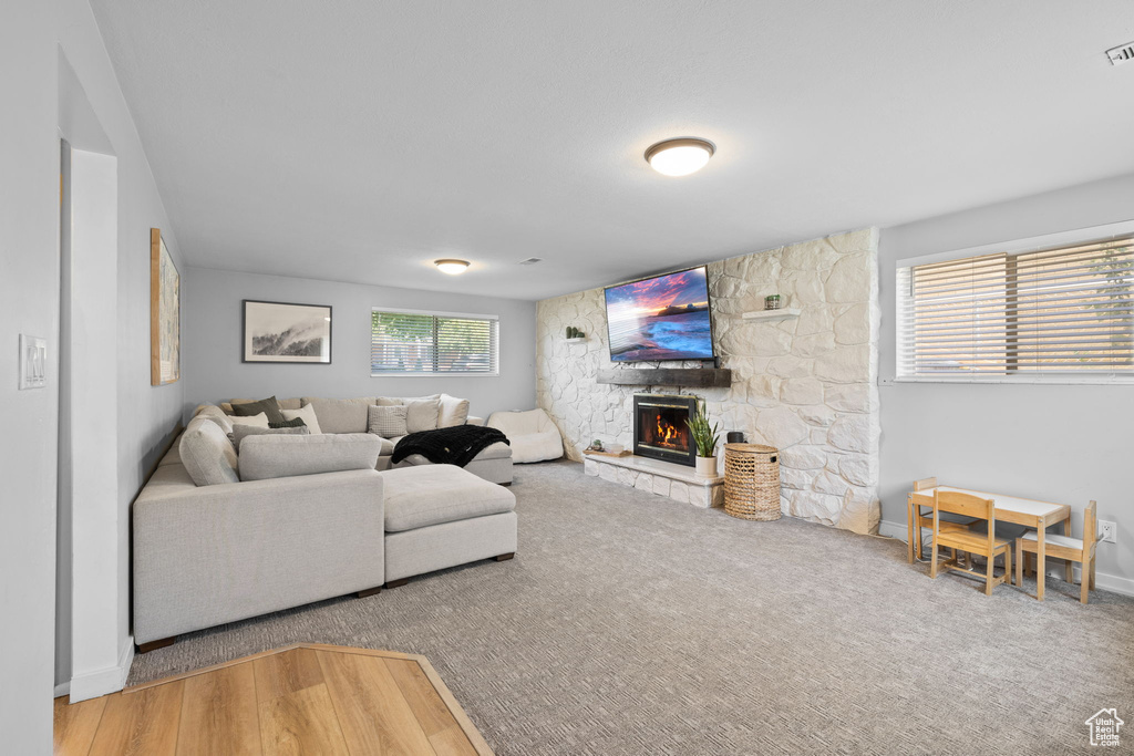 Living room featuring a stone fireplace and carpet flooring