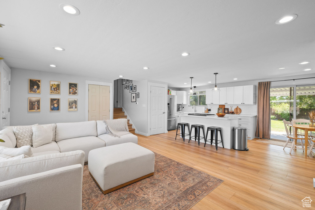 Living area featuring recessed lighting, plenty of natural light, light wood-style floors, and stairway