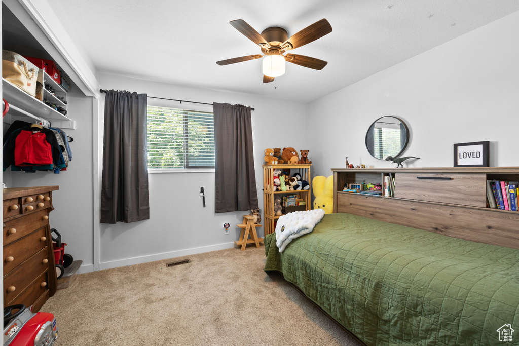 Carpeted bedroom with baseboards and a ceiling fan