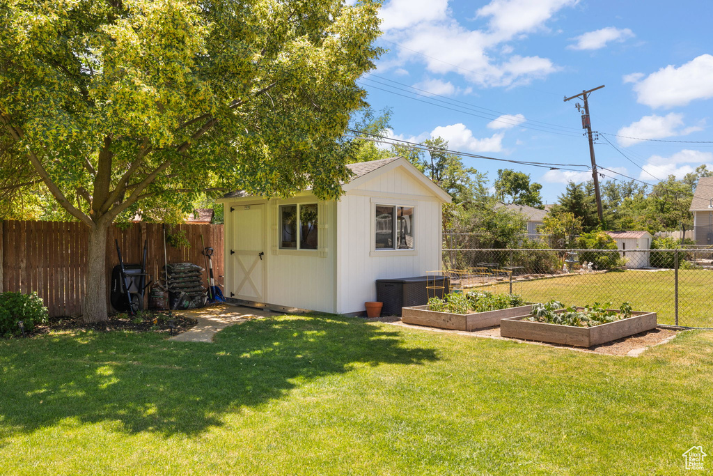 View of shed with a vegetable garden and a fenced backyard