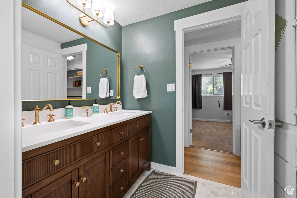 Full bathroom with double vanity and wood finished floors