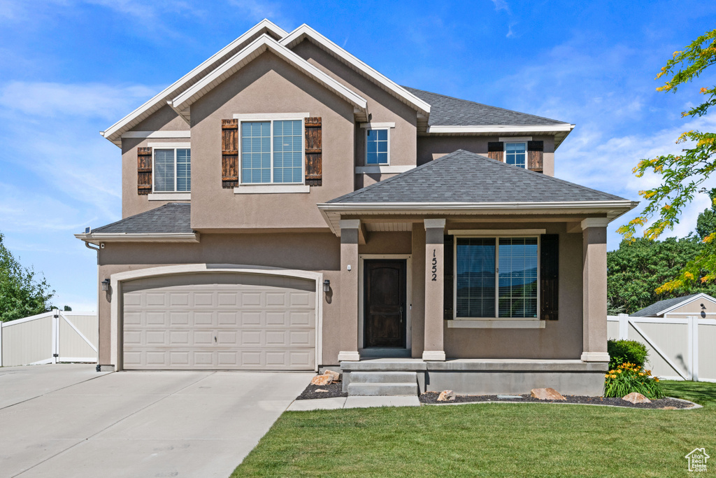 View of front of home featuring a gate, driveway, a garage, and stucco siding