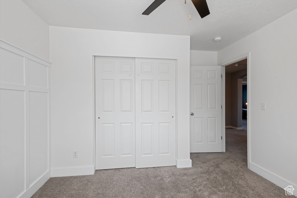 Unfurnished bedroom featuring carpet, a closet, and ceiling fan