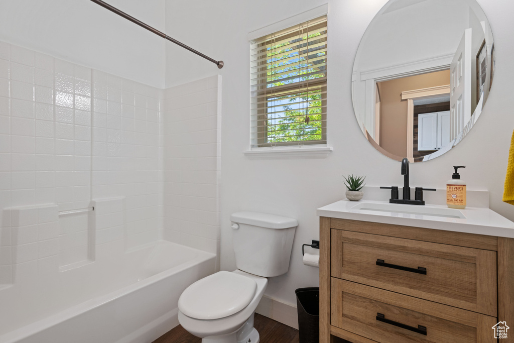Full bath featuring vanity, bathing tub / shower combination, and wood finished floors