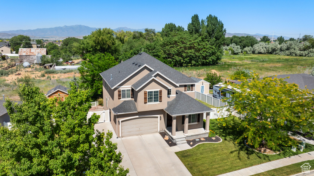 Aerial view of property and surrounding area featuring a mountainous background