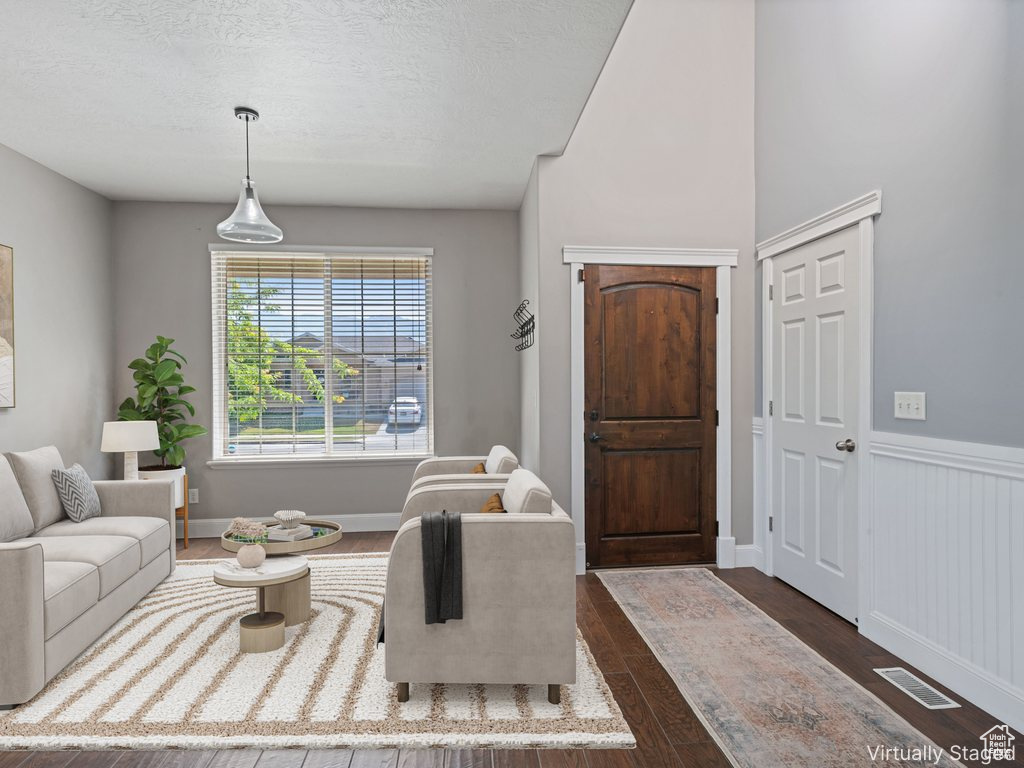 Living area featuring dark wood-type flooring and a textured ceiling