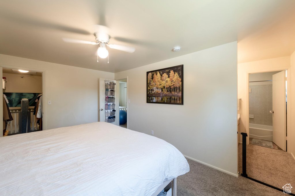 Carpeted bedroom with a ceiling fan and connected bathroom