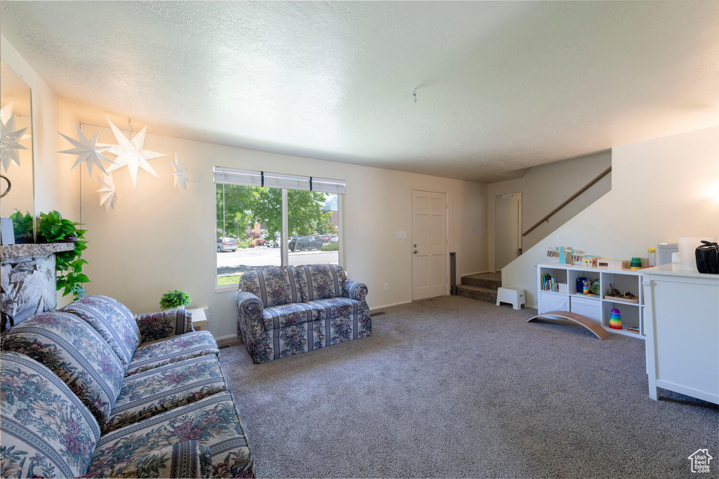 Carpeted living area featuring stairway and a textured ceiling