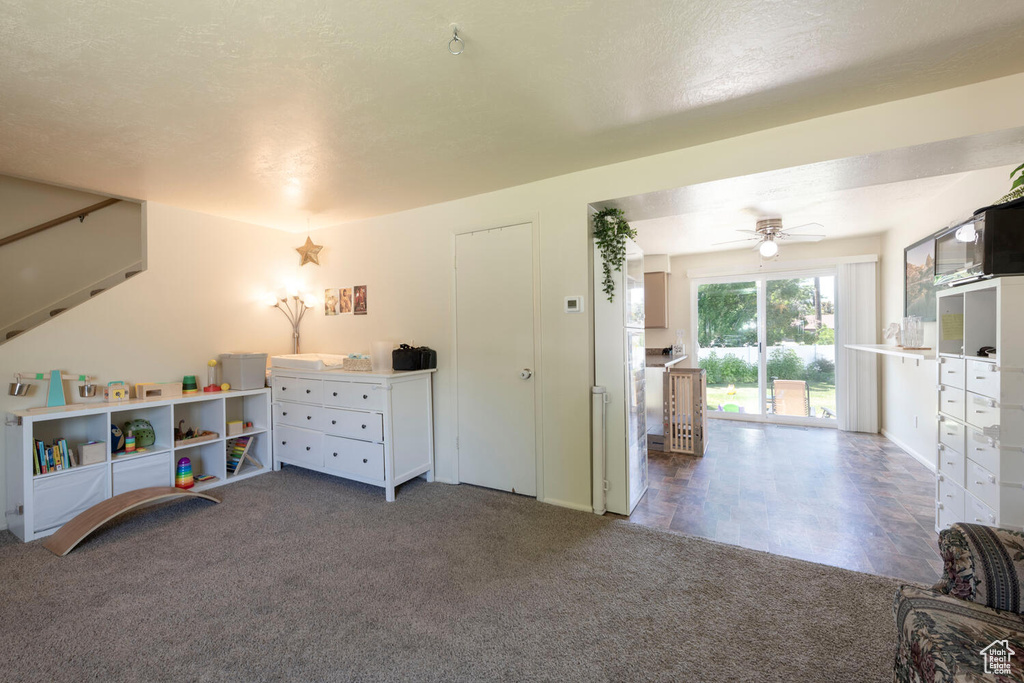 Recreation room with carpet floors and a ceiling fan