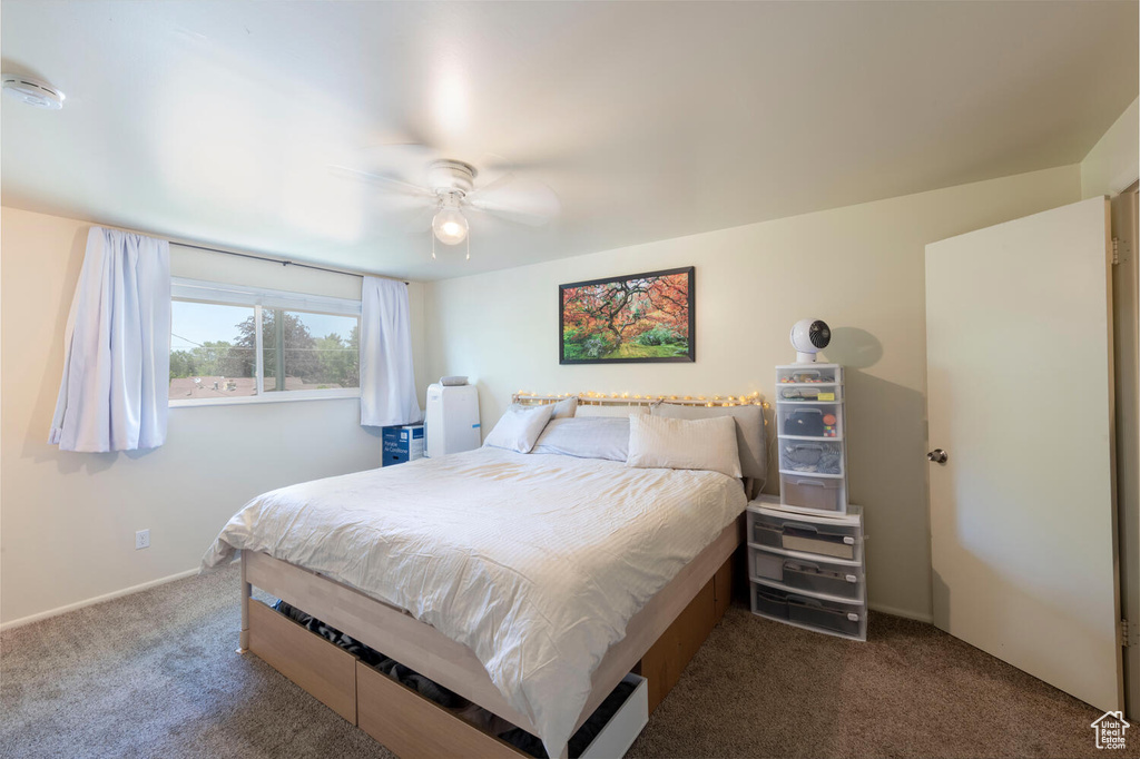 Carpeted bedroom featuring ceiling fan