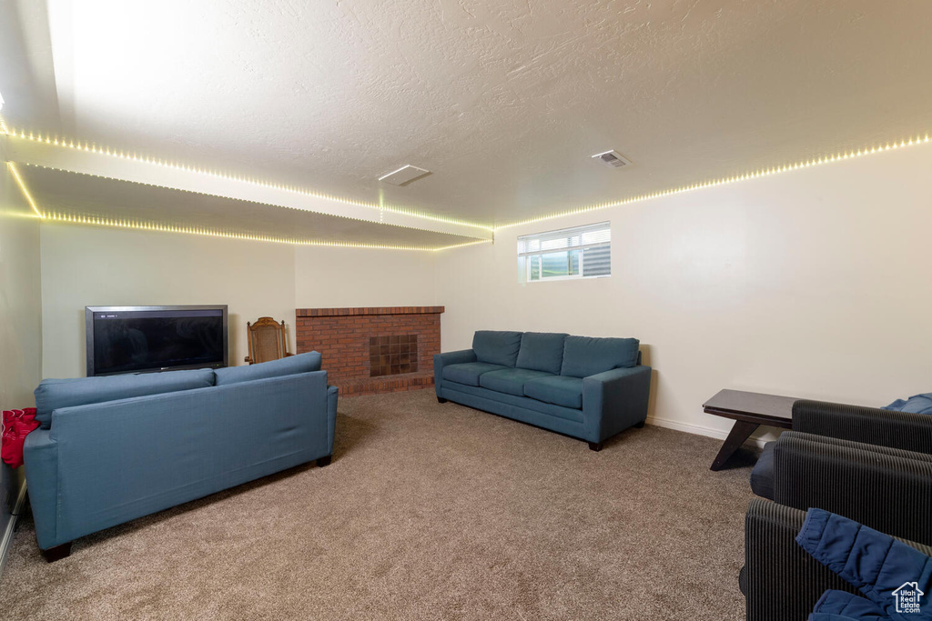 Carpeted living area with a brick fireplace and a textured ceiling