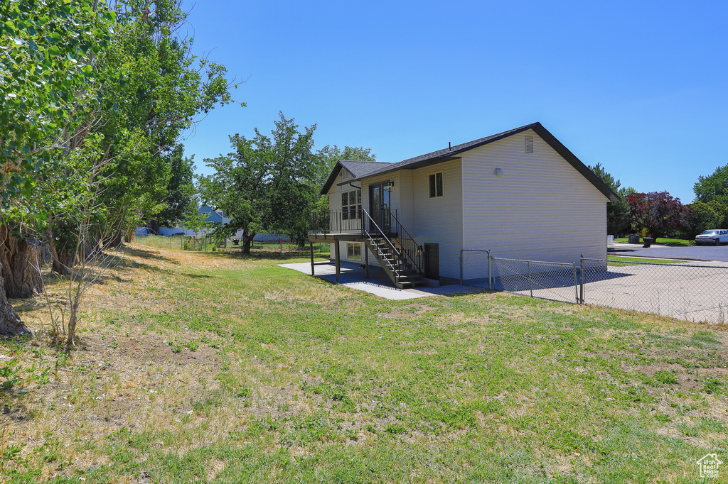 Back of property with a fenced backyard, stairway, and a patio