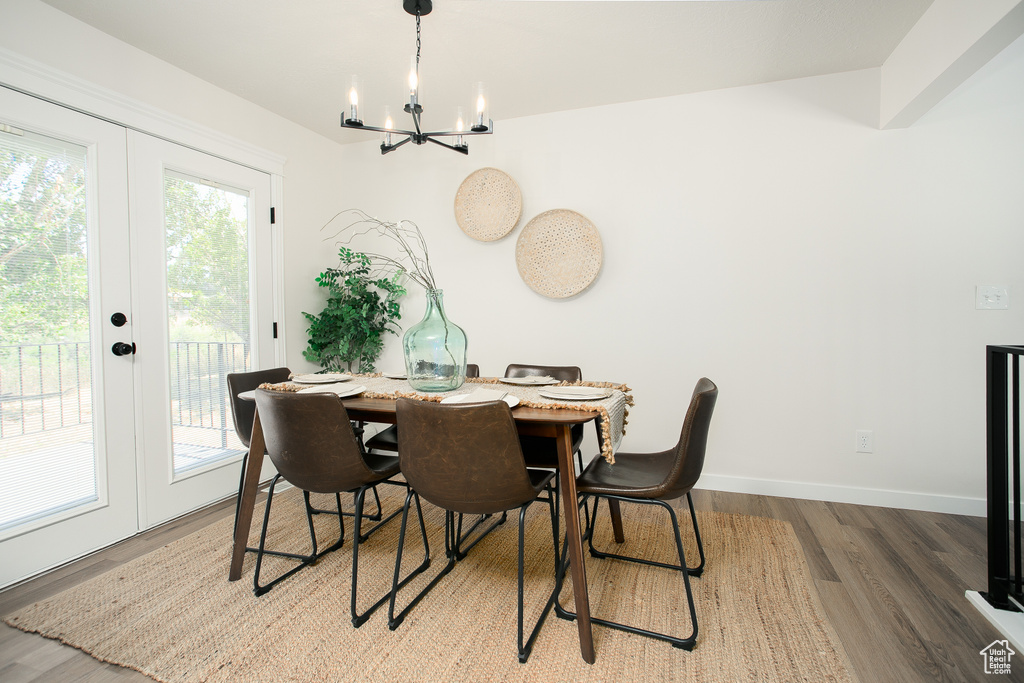 Dining space with a chandelier, french doors, and wood finished floors