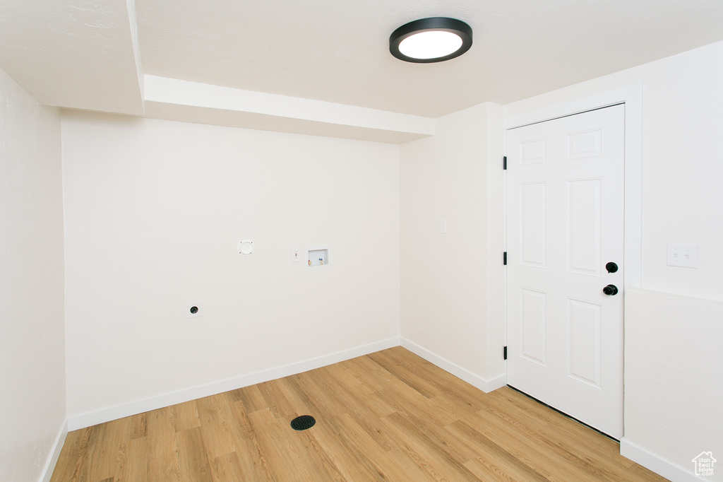 Laundry room with hookup for an electric dryer, light wood finished floors, and hookup for a washing machine
