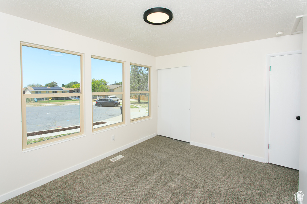 Carpeted empty room with baseboards