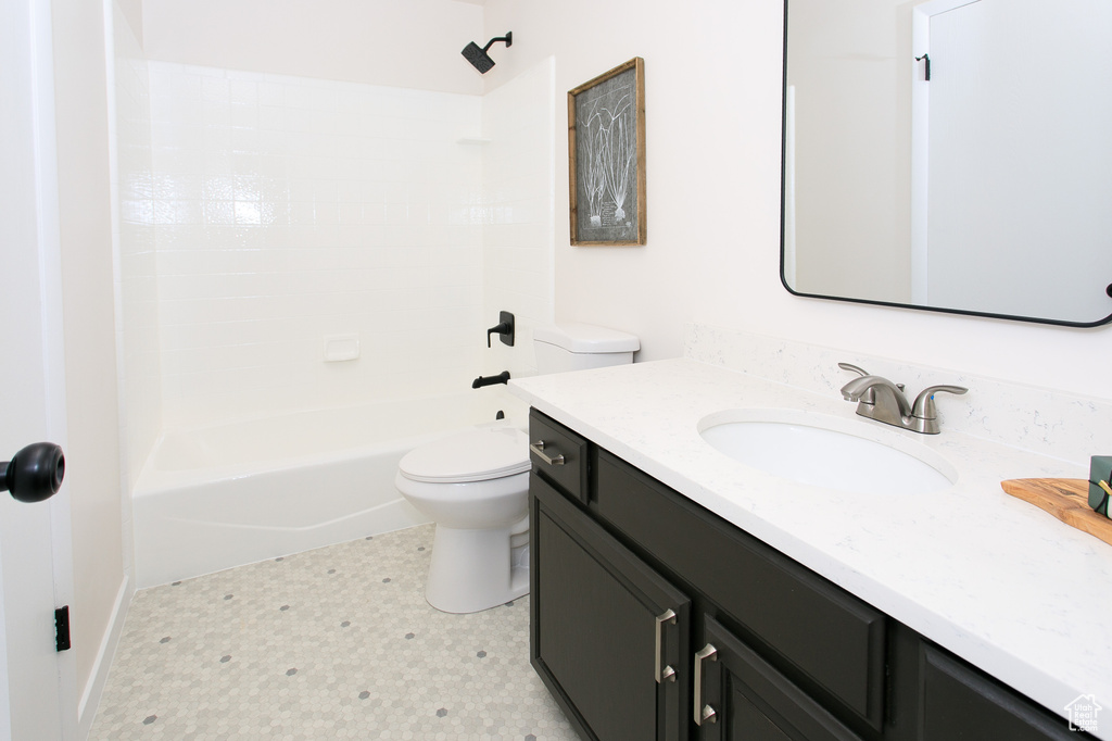 Bathroom featuring vanity, tile patterned floors, and shower / washtub combination