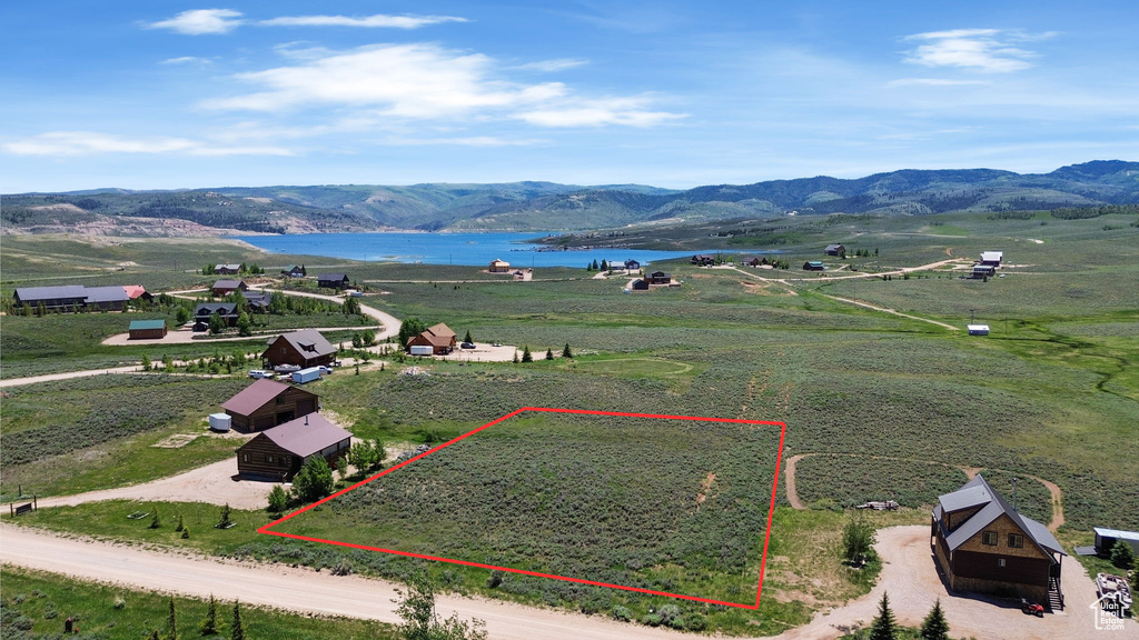 Aerial view of property and surrounding area featuring a water and mountain view and property boundaries highlighted