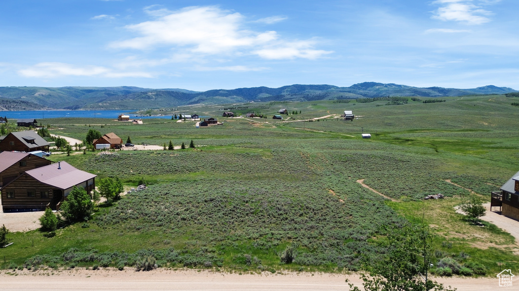 View of mountain backdrop with rural landscape and a large body of water
