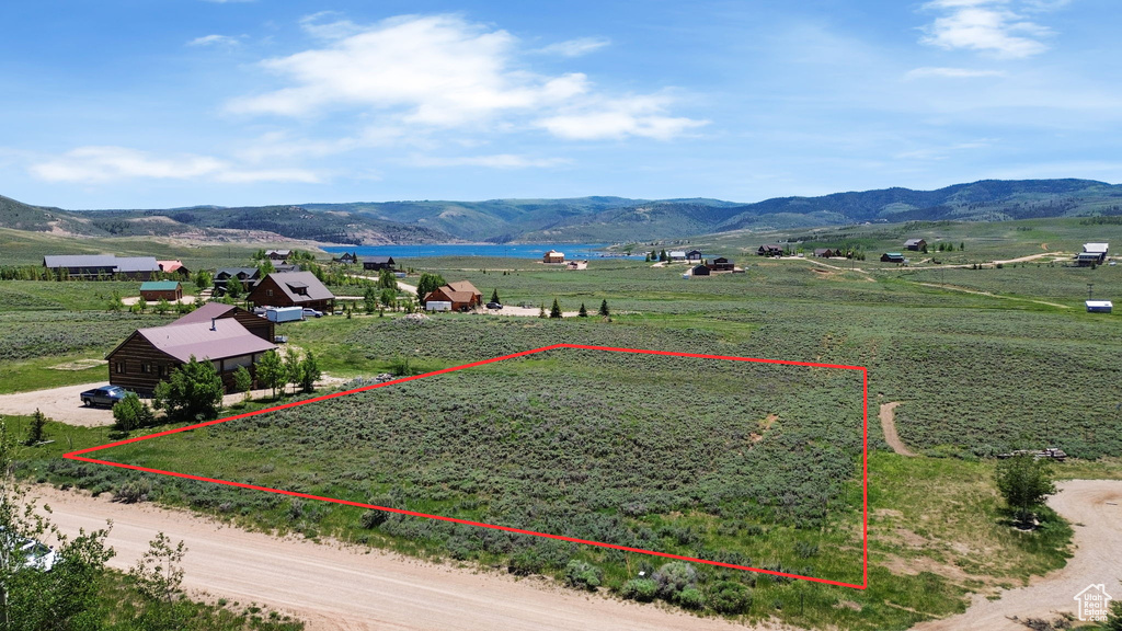 Aerial view of sparsely populated area featuring property parcel outlined and a water and mountain view
