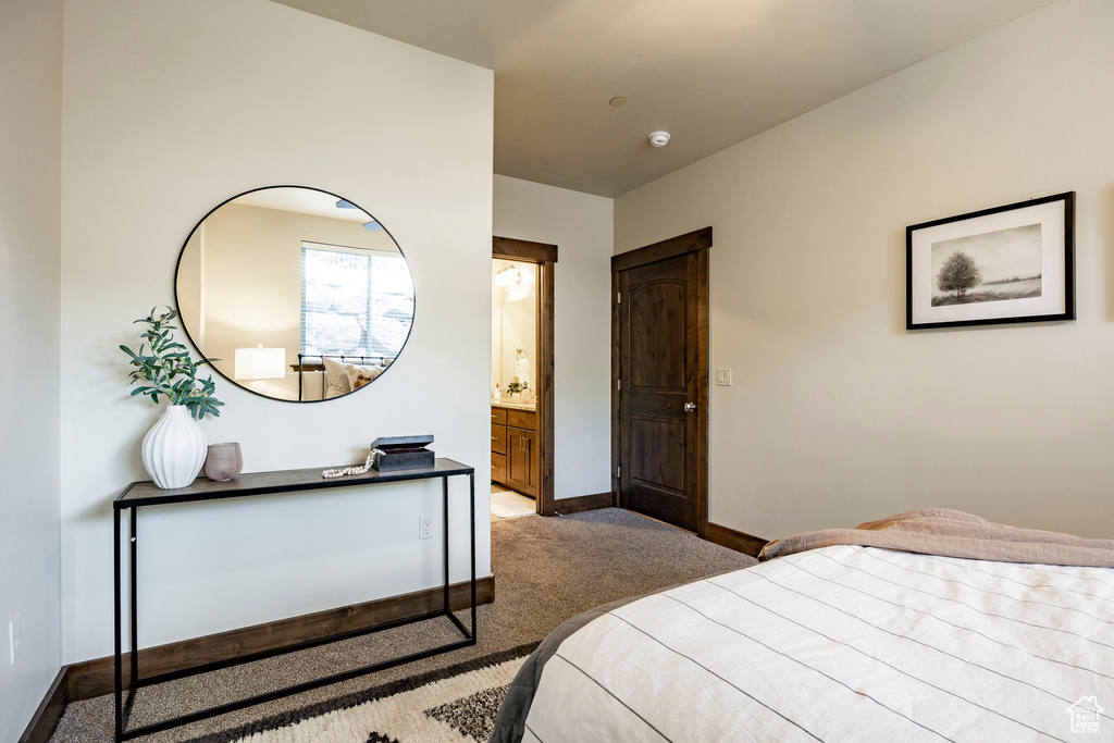 Carpeted bedroom with baseboards and ensuite bathroom