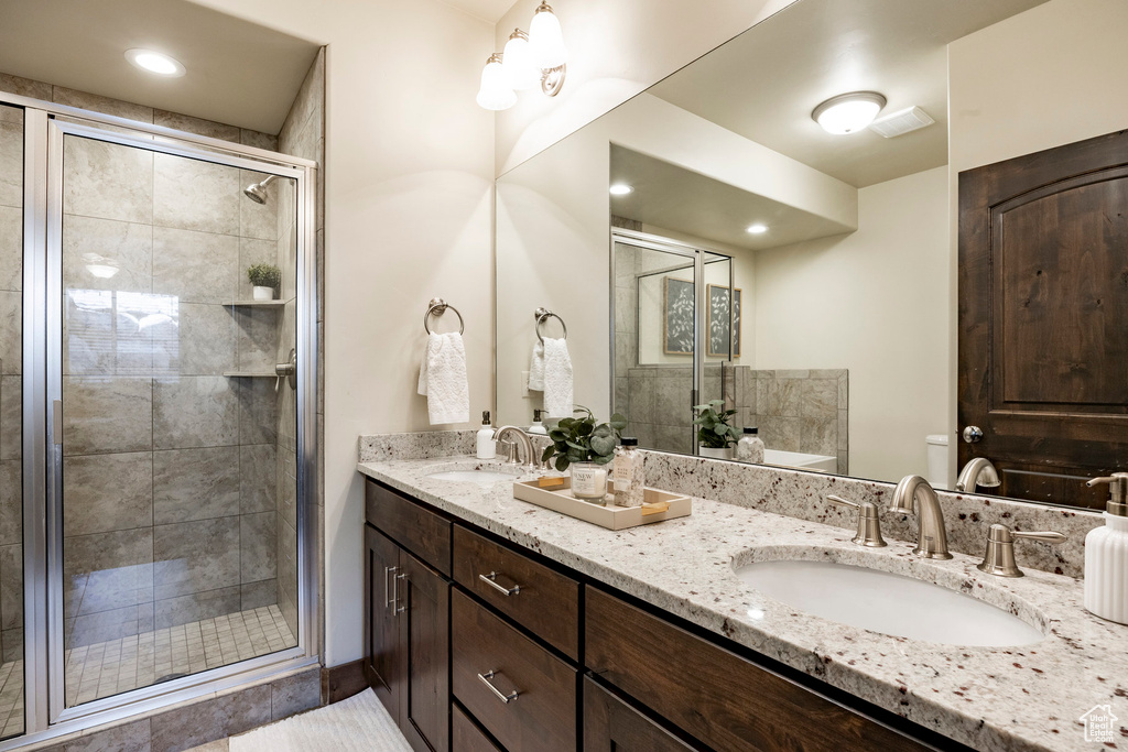 Bathroom featuring double vanity and a stall shower