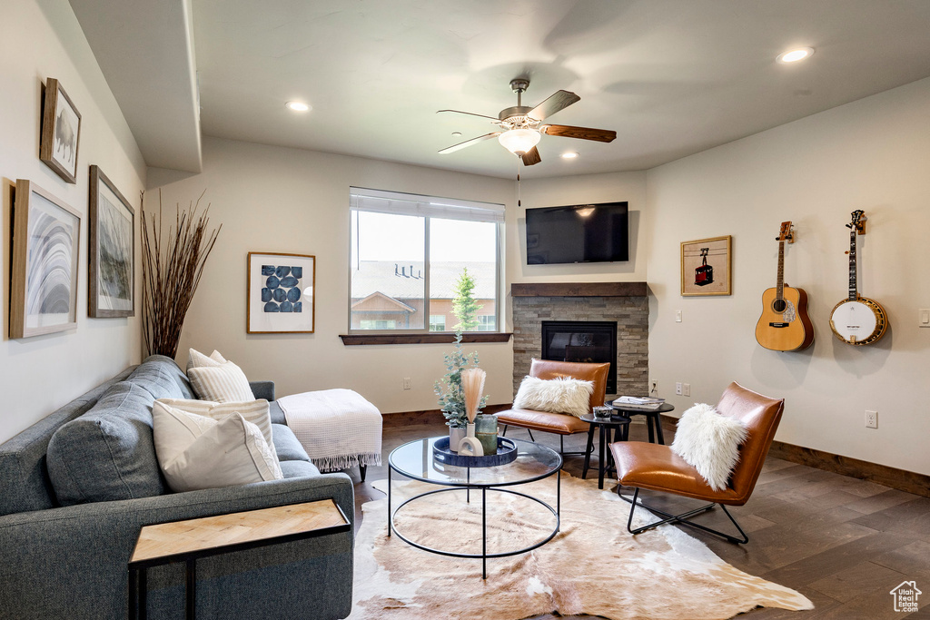 Living area with wood finished floors, a ceiling fan, a fireplace, and recessed lighting
