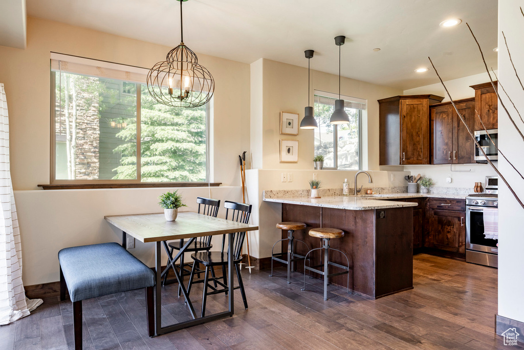 Kitchen with stainless steel appliances, a kitchen bar, plenty of natural light, a peninsula, and recessed lighting