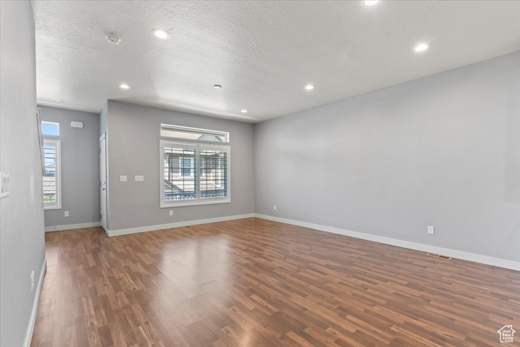 Unfurnished room featuring wood finished floors, a textured ceiling, and recessed lighting