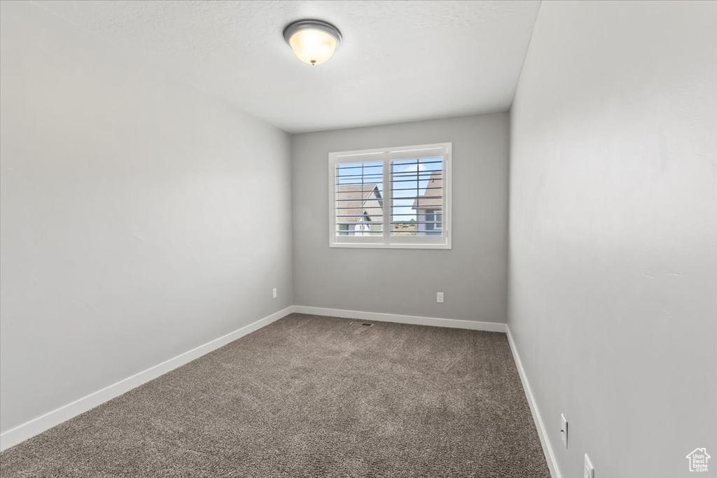 Empty room with carpet flooring and baseboards