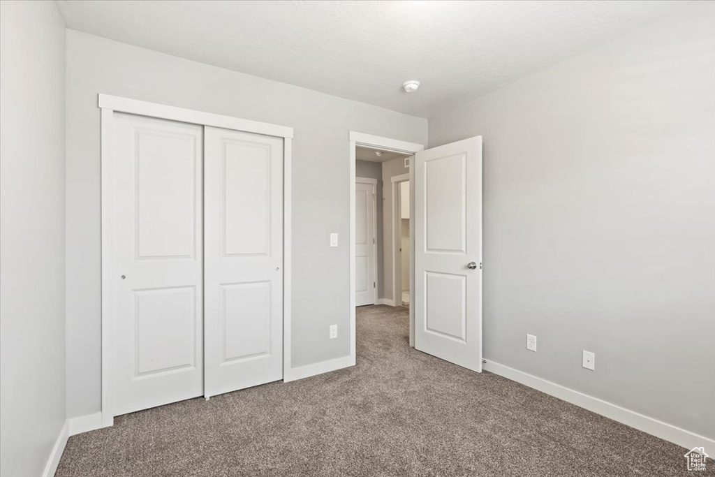 Unfurnished bedroom featuring carpet and a closet