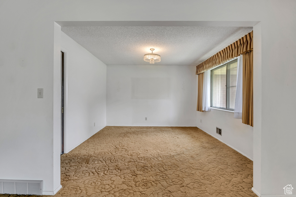 Unfurnished room with a textured ceiling and carpet floors