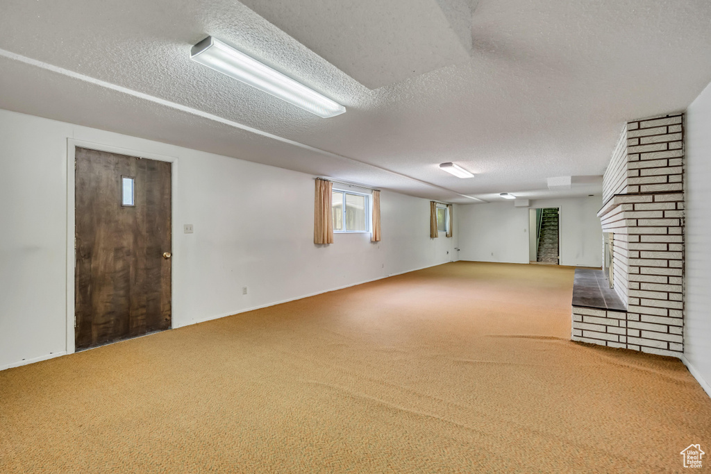 Below grade area featuring carpet, a textured ceiling, and a fireplace
