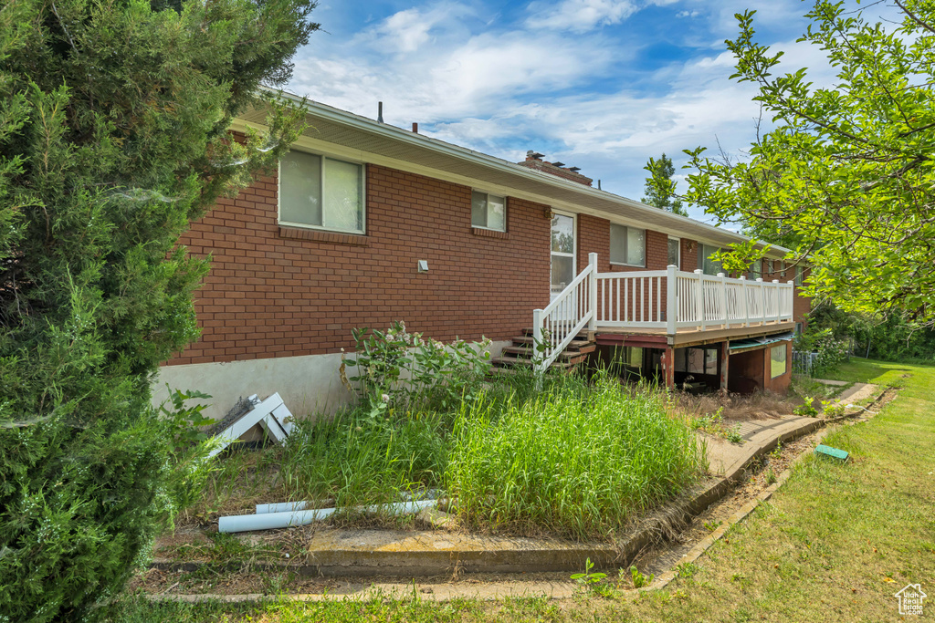 Rear view of property with a wooden deck and brick siding