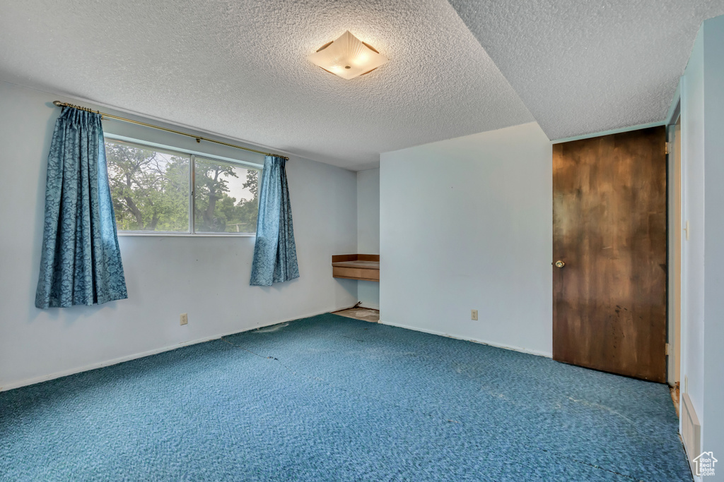 Unfurnished bedroom with carpet flooring and a textured ceiling